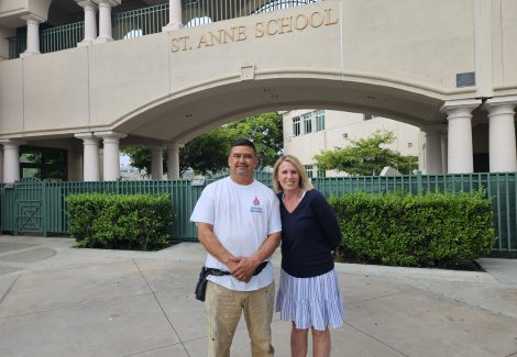 man and woman posing in front of school