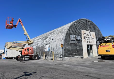 painter on boom lift next to industrial building