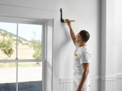 Man Painting White Wall Near Window