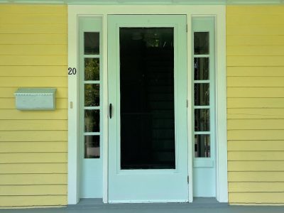 White Front Door of yellow house in Warwick, NY, after completed residential exterior painting project by CertaPro Painters of Orange County, NY