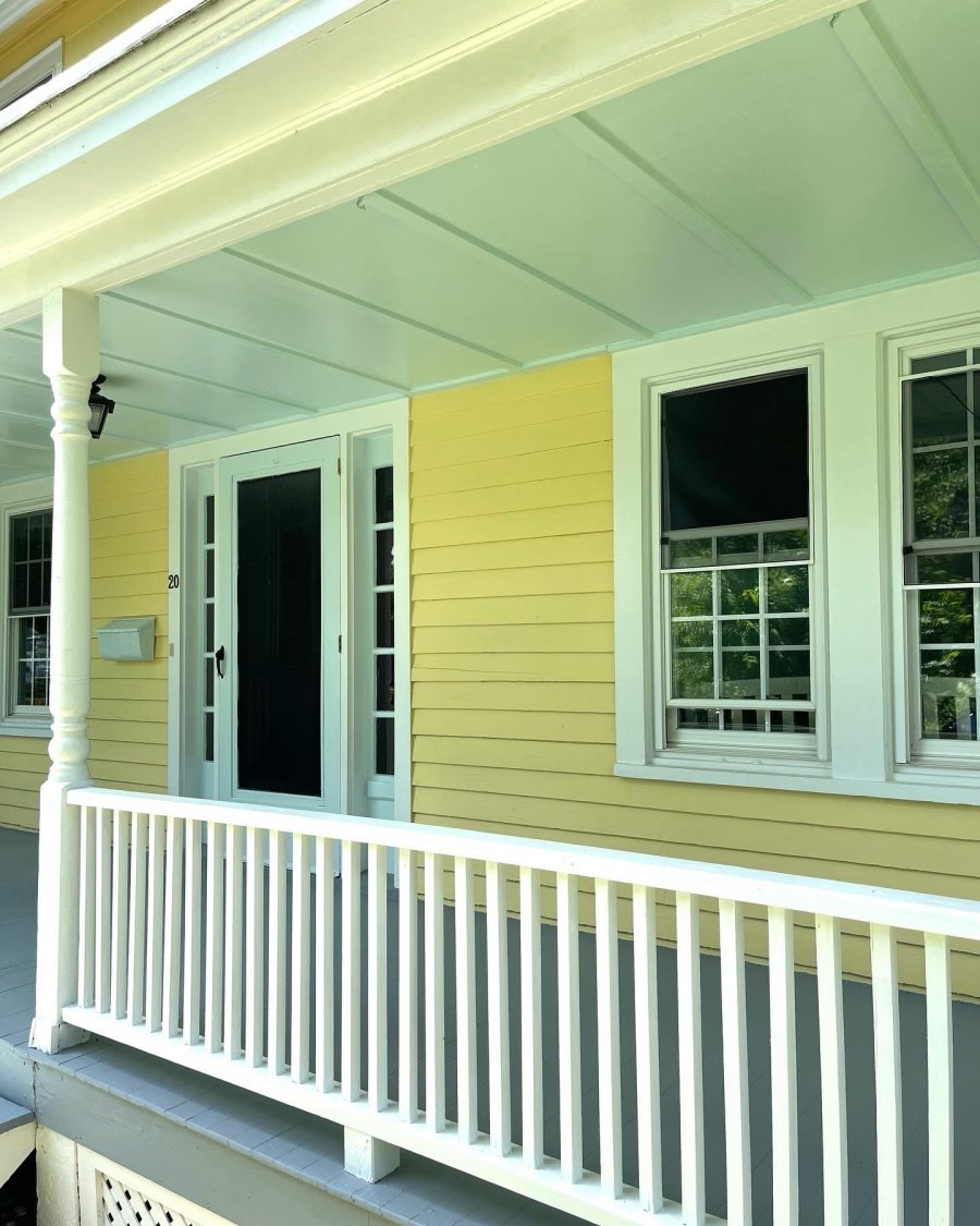 Side Angle of front porch with white railings and yellow exterior in Warwick, NY, after completed residential exterior painting project by CertaPro Painters of Orange County, NY Preview Image 1