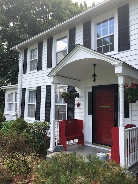 Front Angle of white house with red door in Warwick, NY, after completed painting project by Certapro Painters of Orange County, NY - Angle 2 Preview Image 2