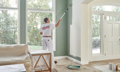 CertaPro crew member painting interior wall