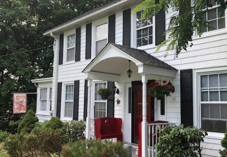 Front Angle of white house with red door in Warwick, NY, after completed painting project by certapro painters of Orange County, NY