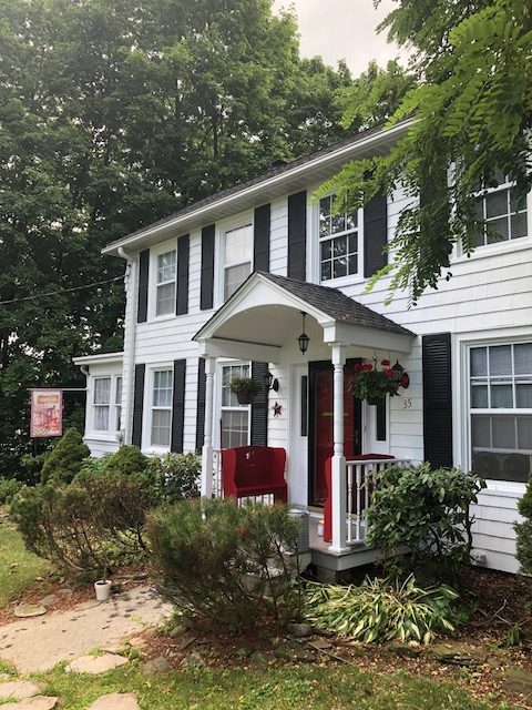 Front Angle of white house with red door in Warwick, NY, after completed painting project by certapro painters of Orange County, NY Preview Image 1