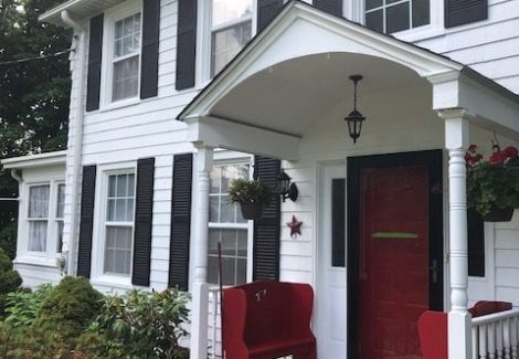 Front Angle of white house with red door in Warwick, NY, after completed painting project by Certapro Painters of Orange County, NY - Angle 2