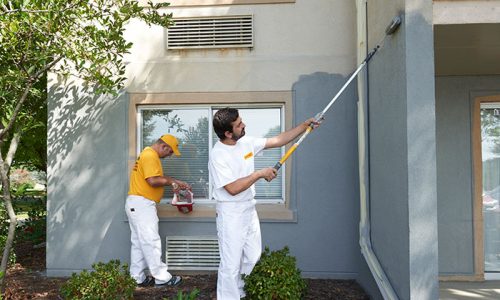 two certapro team members exterior painting stucoo home