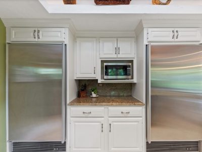 The kitchen cabinets between the refrigerators were painted white.