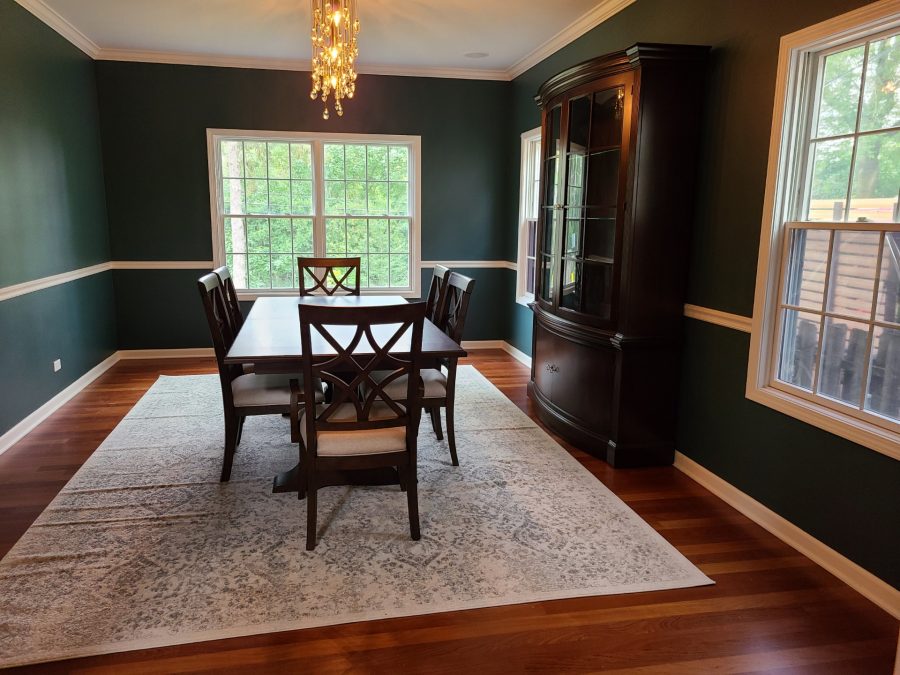 Dining room painted a forest green with a white chair rail and white trim. Preview Image 7