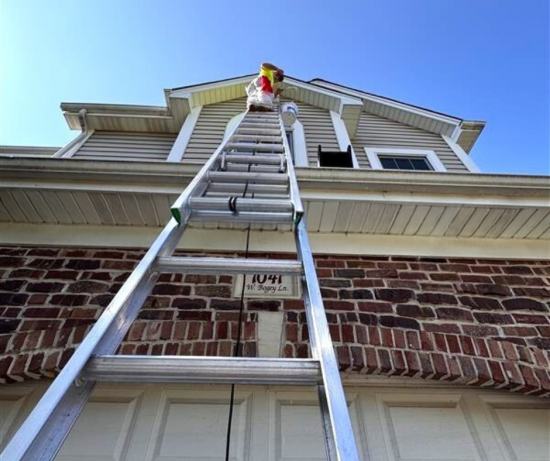 painter on ladder above home garage door