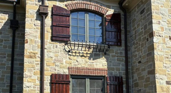 stone house exterior with stained wooden shutters