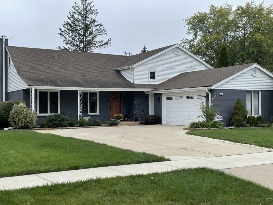 Gray painted brick and stone paired with white siding.