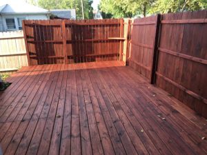 a deck in Pasadena and a matching fence are both stained using clear stain.