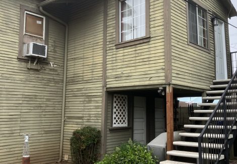 craftsman style house and staircase with damaged and worn siding