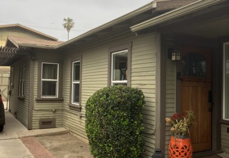 front and side view of house with damaged and worn siding