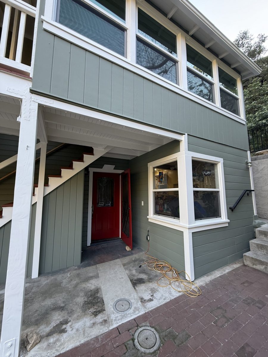 light green painted house with white trim and red door