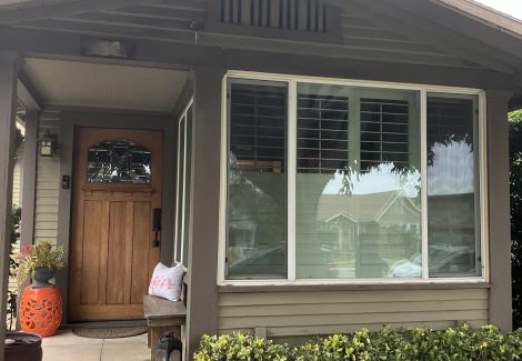 front door of craftsman style house with damaged and worn siding