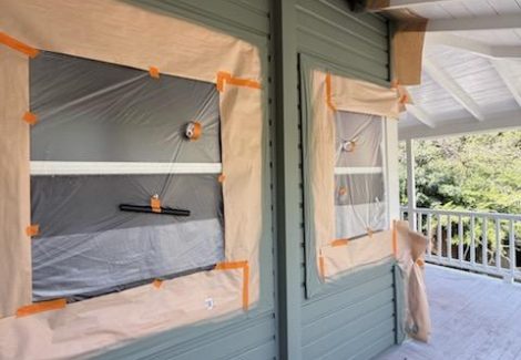 house with protective wrap during painting
