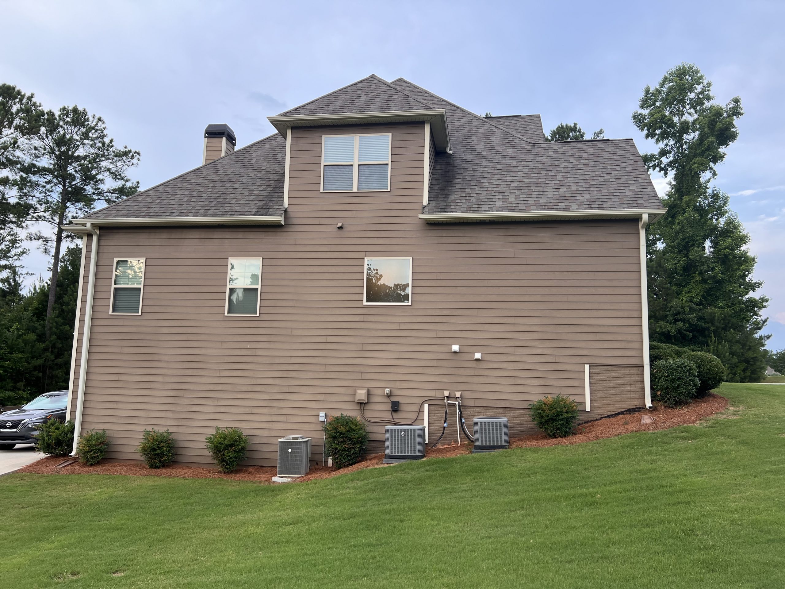 Back of brown home in Senoia before painting project