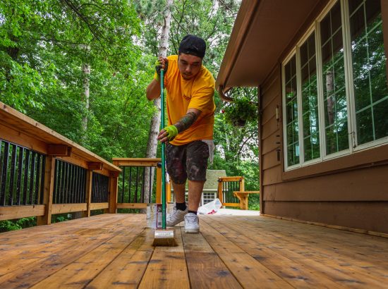 CertaPro Crew Member applying a stain to a deck