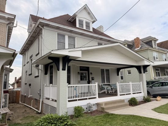 white painted brick home exterior with black accents.