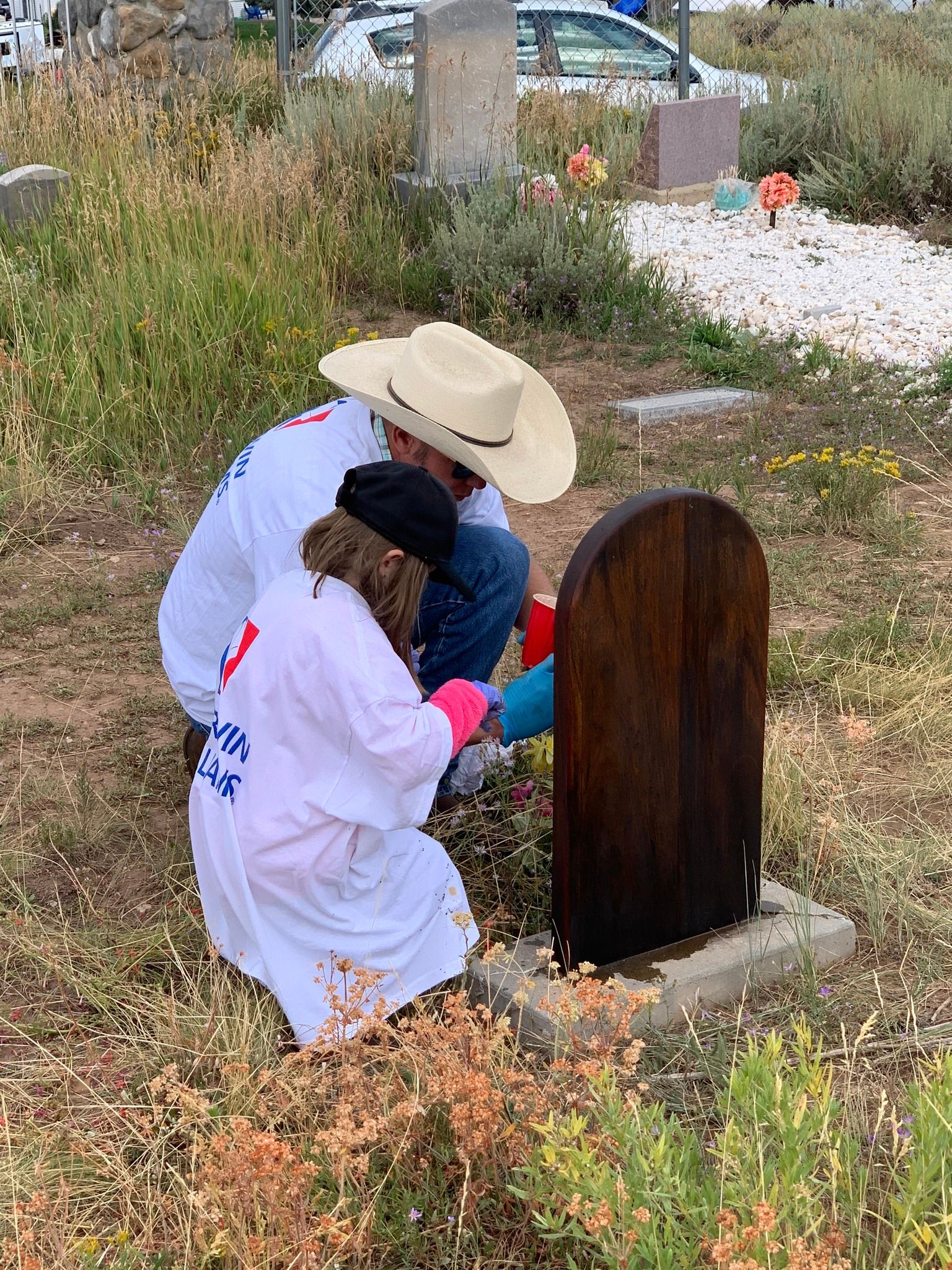 two people staining a grave