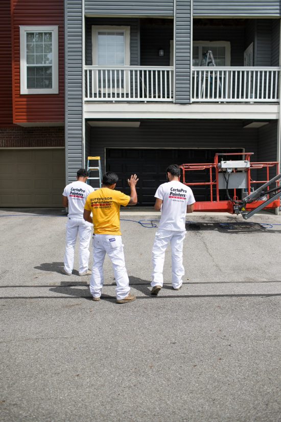 CertaPro Team Members standing in front of a Home Owner's Association Apartment they are painting