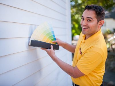 CertaPro Color Consultant displaying paint color choices on a white exterior wall
