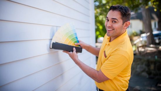 CertaPro Color Consultant displaying paint color choices on a white exterior wall