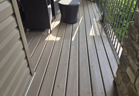 back of home with painted vinyl siding and deck