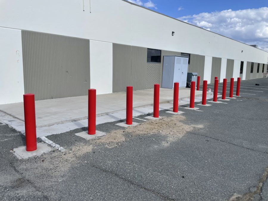 red painted safety bollards outside of industrial building Preview Image 5
