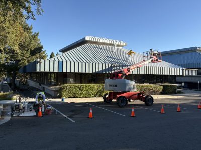 painters in boom lift working on commercial roof