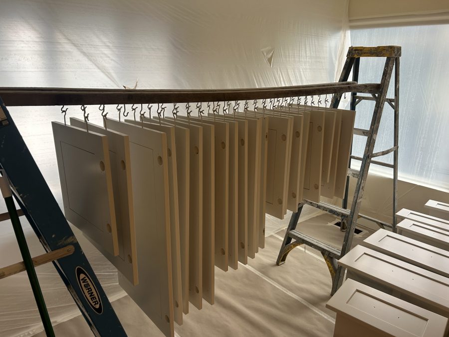 cabinet doors suspended on rack to dry after painting Preview Image 12