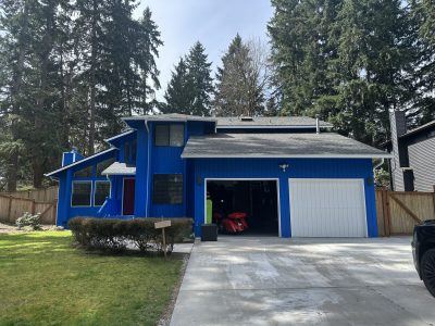 blue pained house exterior with white trim and garage doors