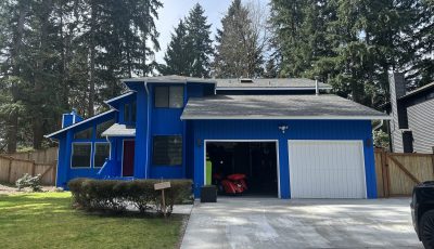 blue pained house exterior with white trim and garage doors