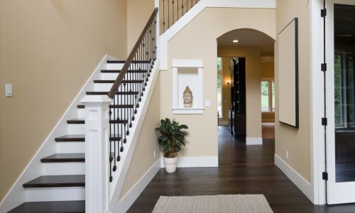 beige_walls_white_brown_stairway_foyer_home_entrance_interior_darkwoodfloors
