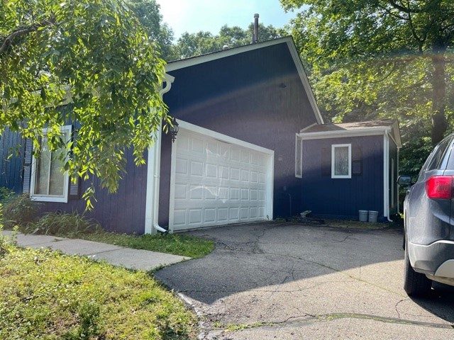 exterior of house painted blue with a white garage door. Preview Image 1