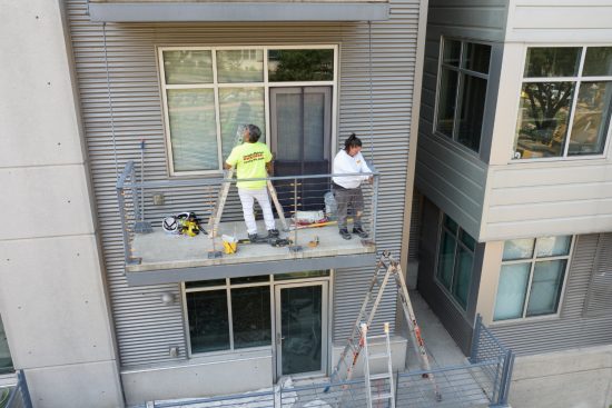 Condo Painting Project arial view with painters touching up balcony railing