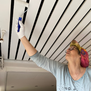 woman painting ceiling in home