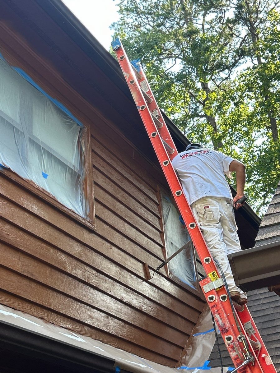 painter on ladder staining house with wood siding Preview Image 10