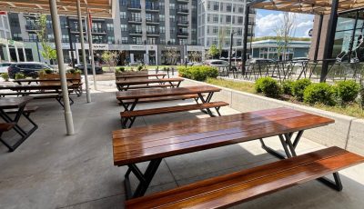 stained wooden picnic tables on restaurant patio