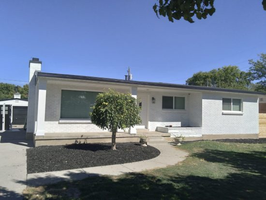 An after image of a brick house in Murray Utah that was painted white.