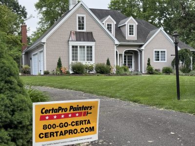 Front view of painted house and driveway with front yard