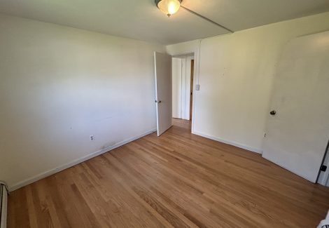 interior room in house with wooden floors and dirty and worn paint on walls