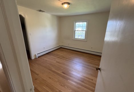 interior room in house with wooden floors and dirty and worn paint on walls