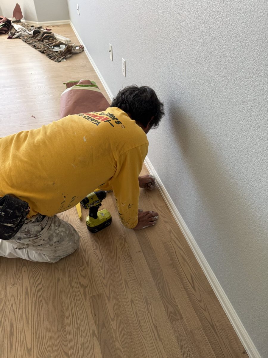 painter working on lower wall trim