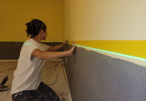 woman using lazor level during interior paint project