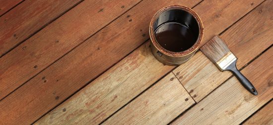 deck staining being done with a paint brush