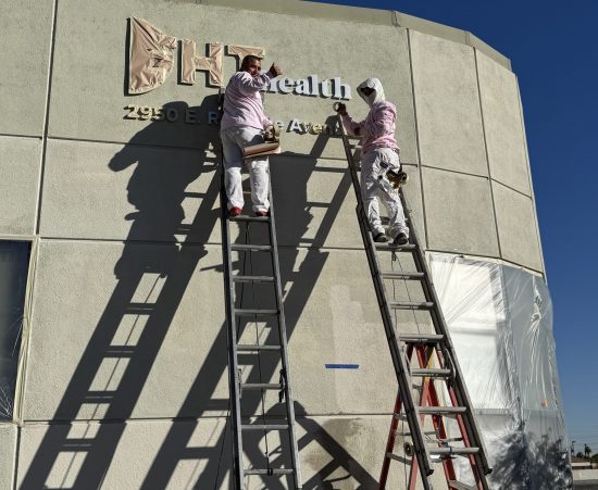 painters on ladders against building exterior during repaint