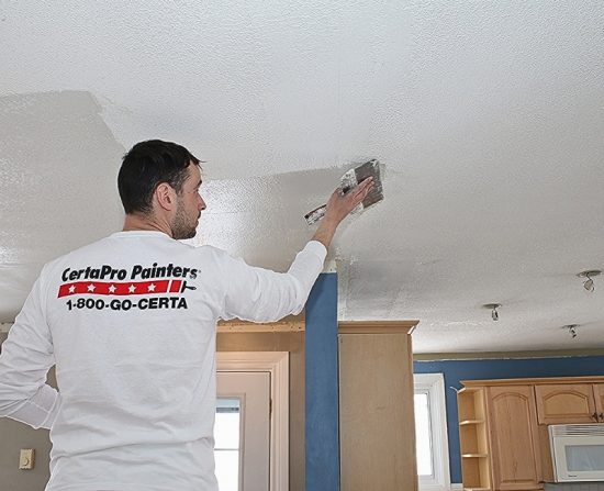 Popcorn ceiling removal services man scrapping off excess ceiling